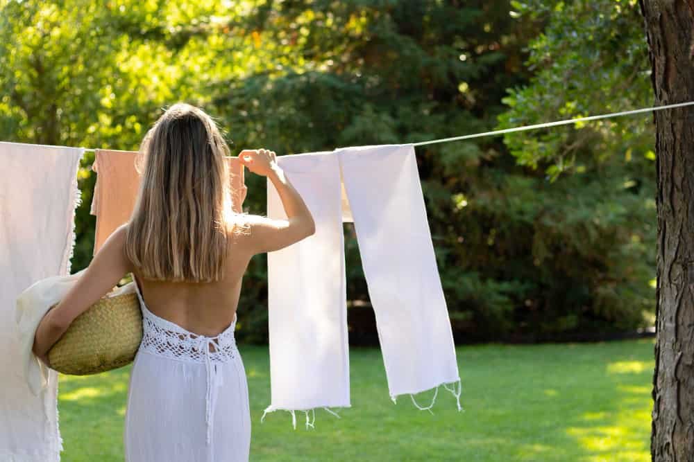 woman hangs clothes in garden