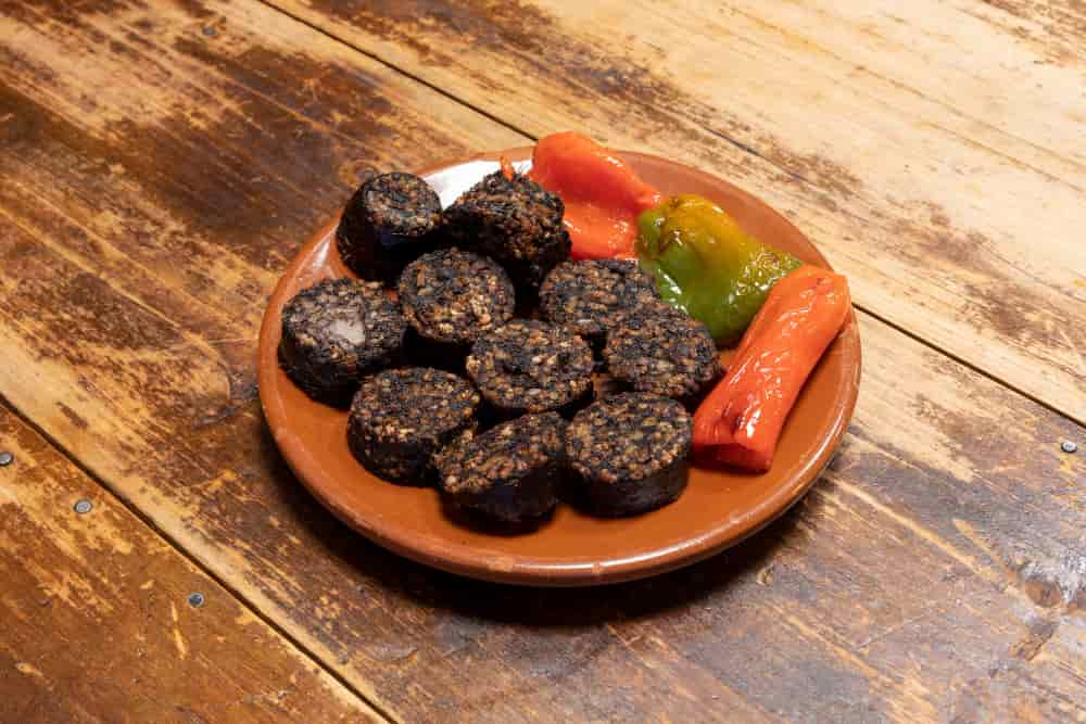 a plate of blood sausage with peppers