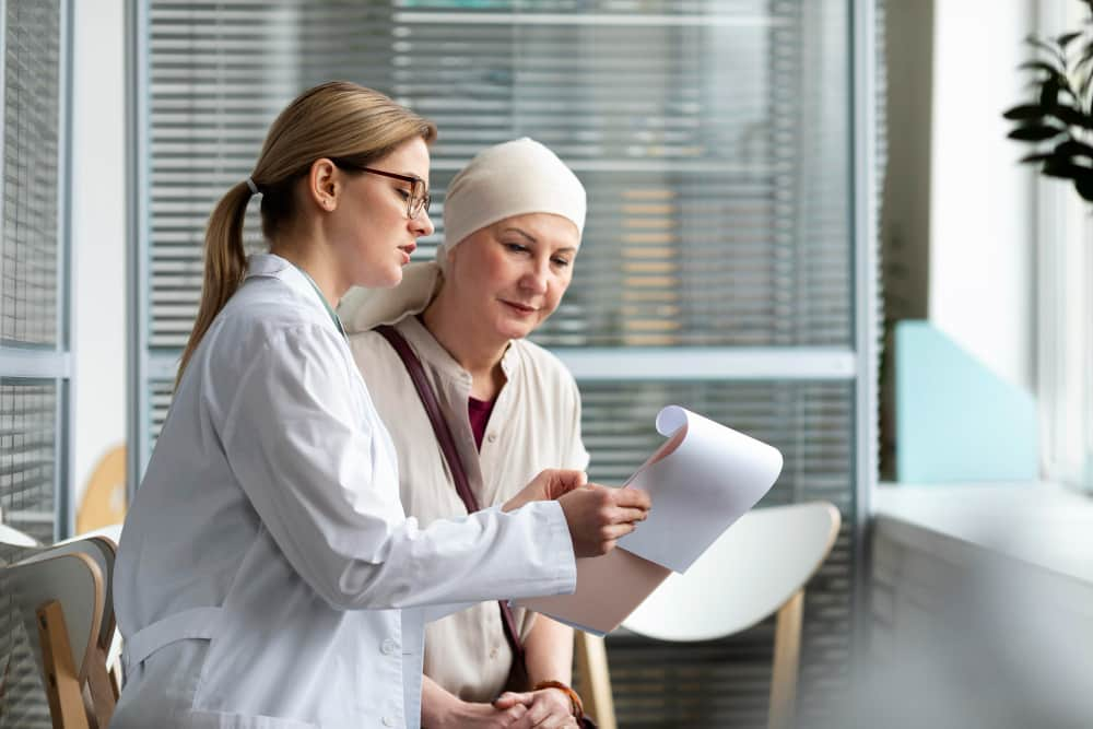 doctor treats elderly woman with cancer