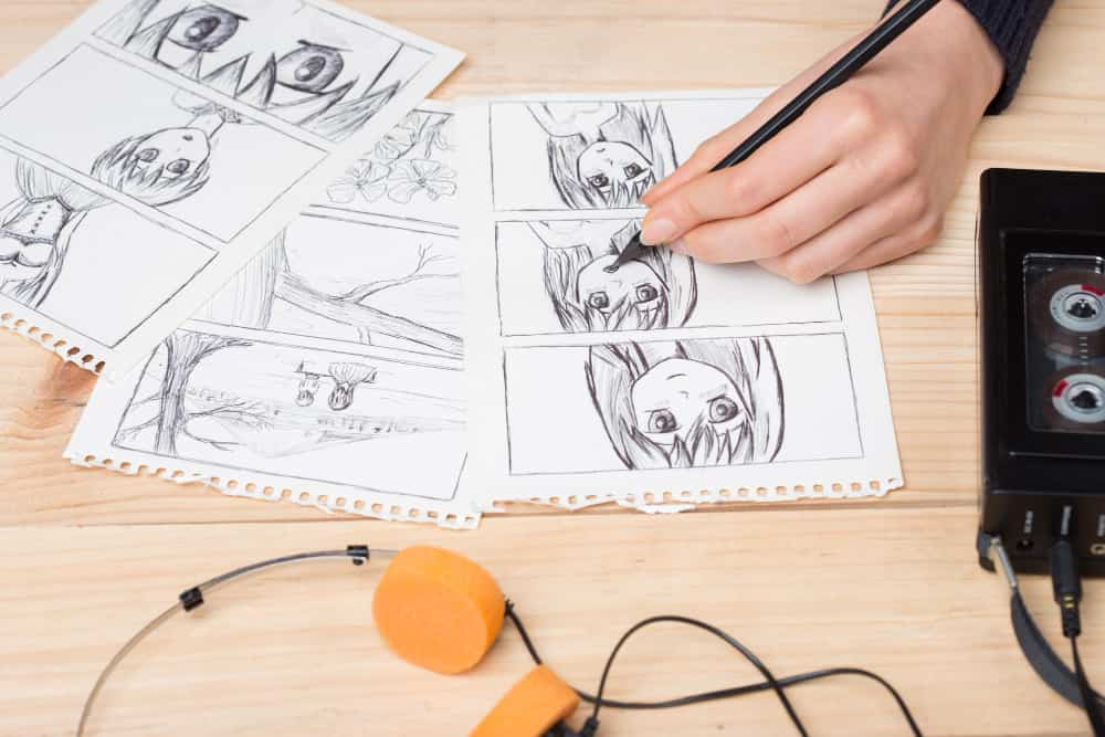 young boy drawing manga at a table