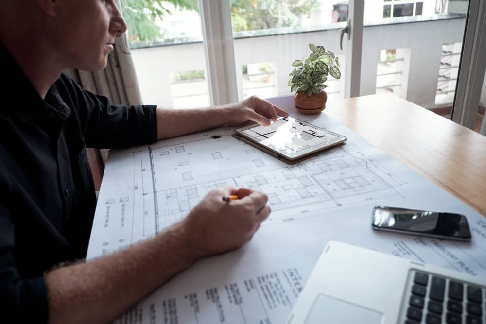 man studies plans for some houses