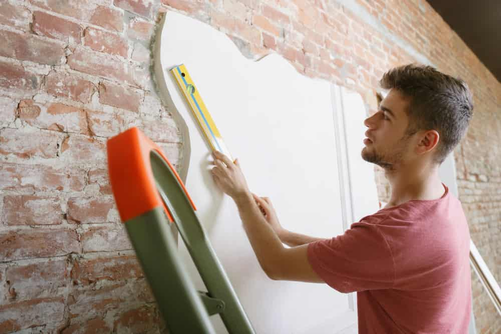 boy insulating an already built wall