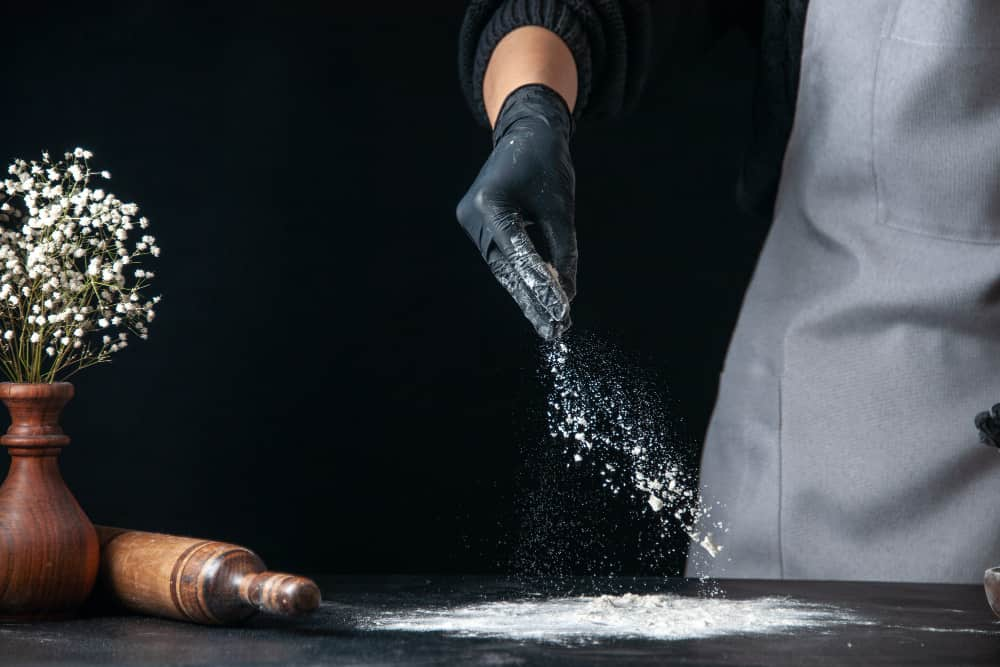 man prepares flour to coat fish