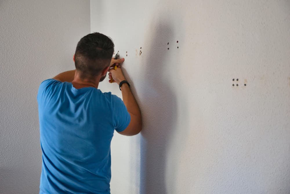 carpenter tries to remove plugs from the wall