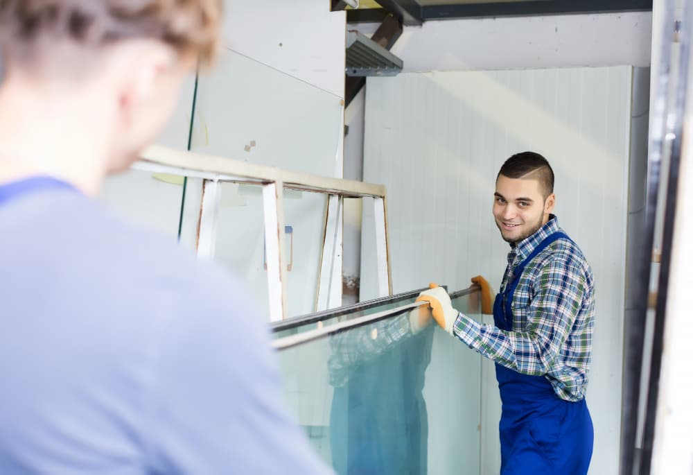 two workers move a tempered glass