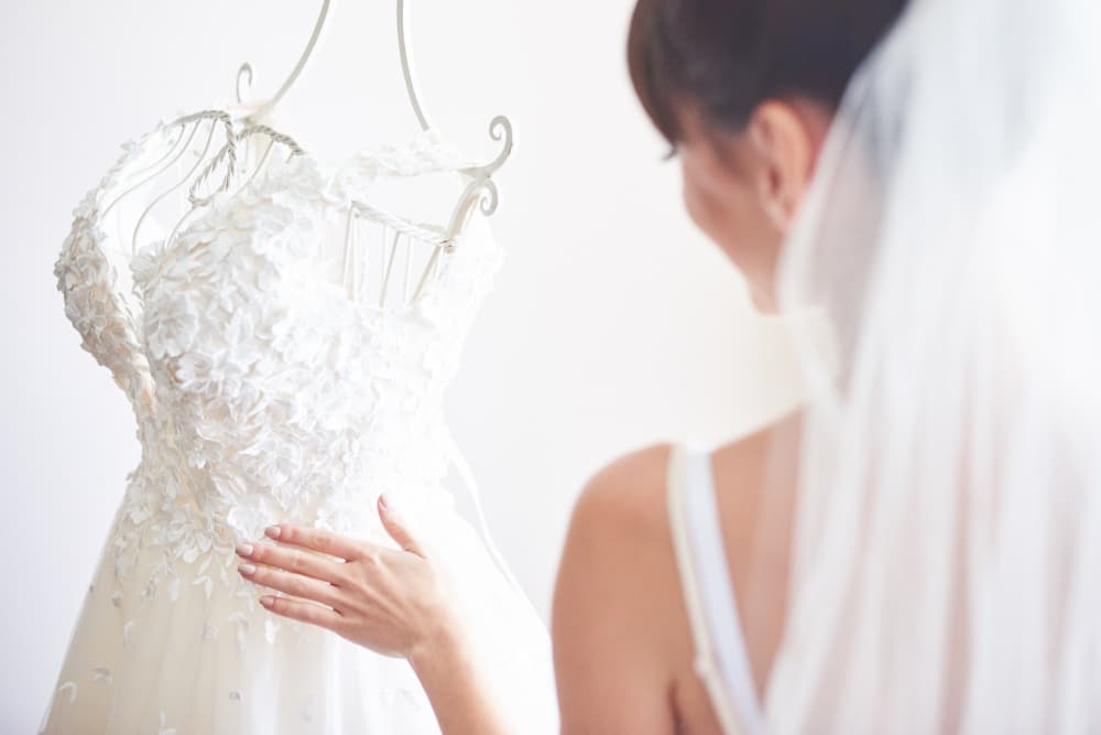 bride touching looking at wedding dress